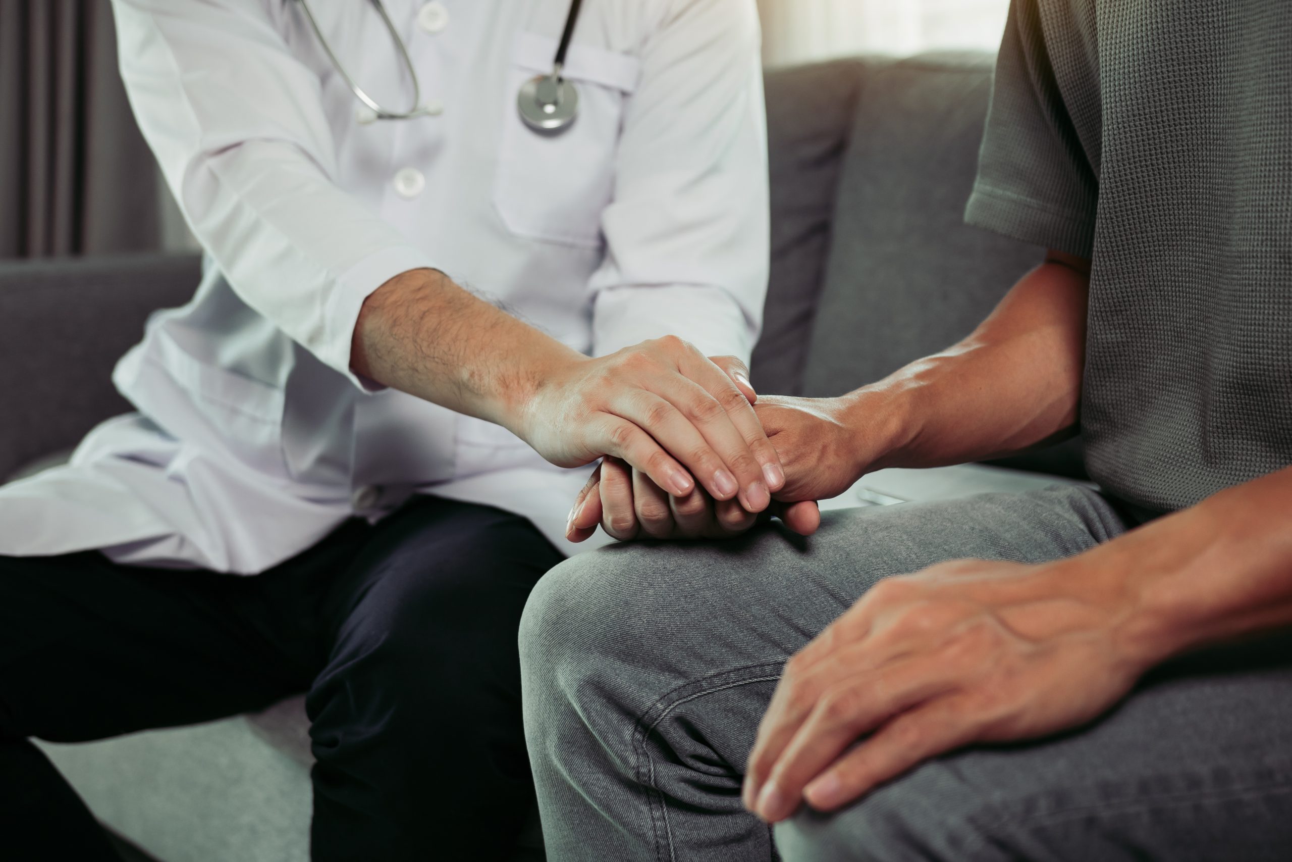 Doctor is holding the hand of the patient by giving him confiden